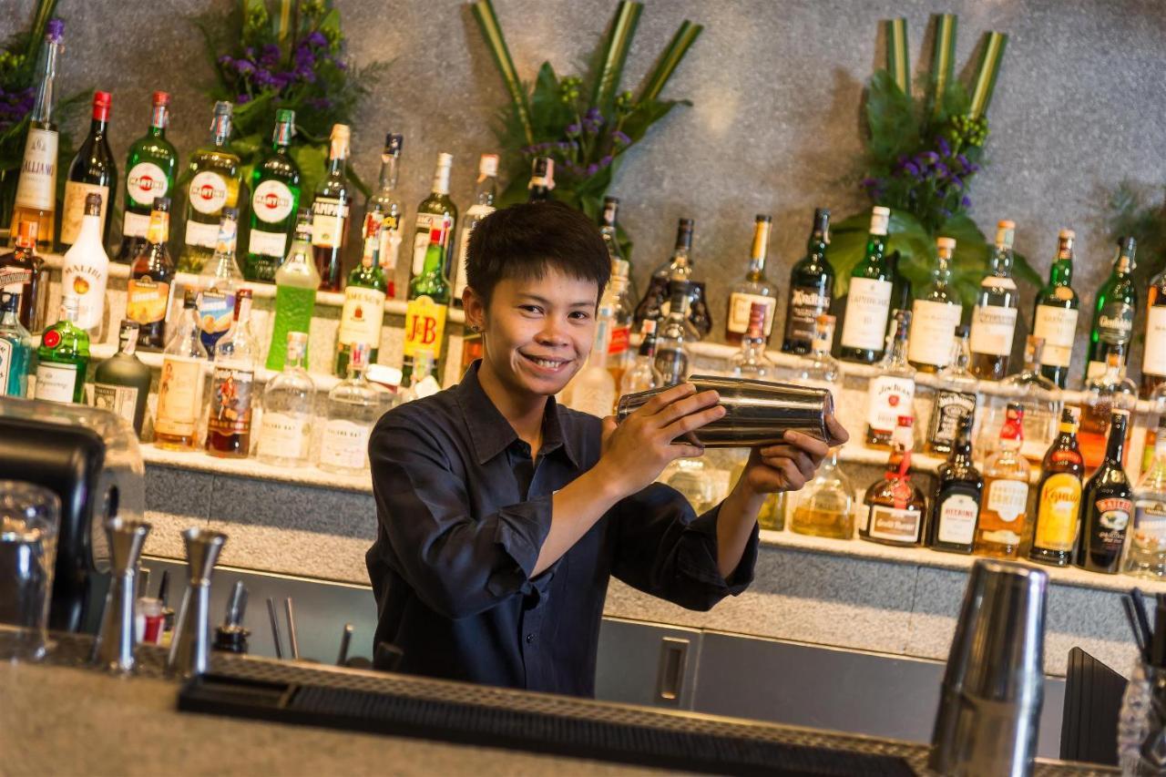 Akara Hotel Бангкок Экстерьер фото A bartender shaking a cocktail